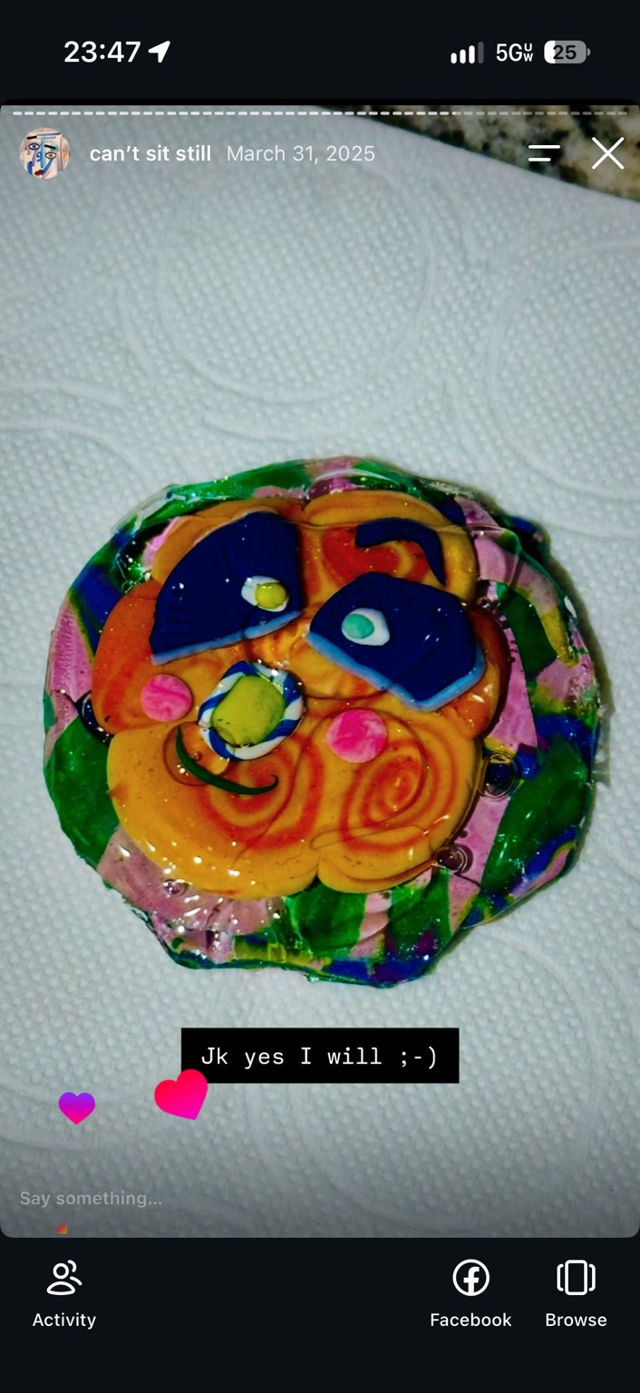 First clay and resin experiment: an uneven, colorful face with blue eyes and orange swirls