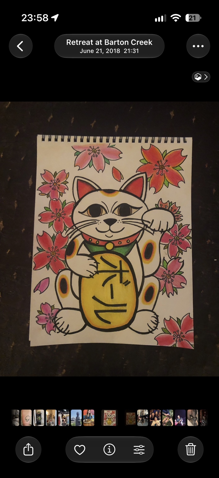 Lucky cat drawing surrounded by pink and red blossoms, holding a gold oval with lettering created as a reference to a friend’s band
