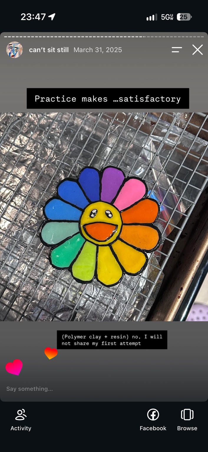 Later polymer-clay and resin flower with rainbow petals, a smiling yellow face, and black outlines